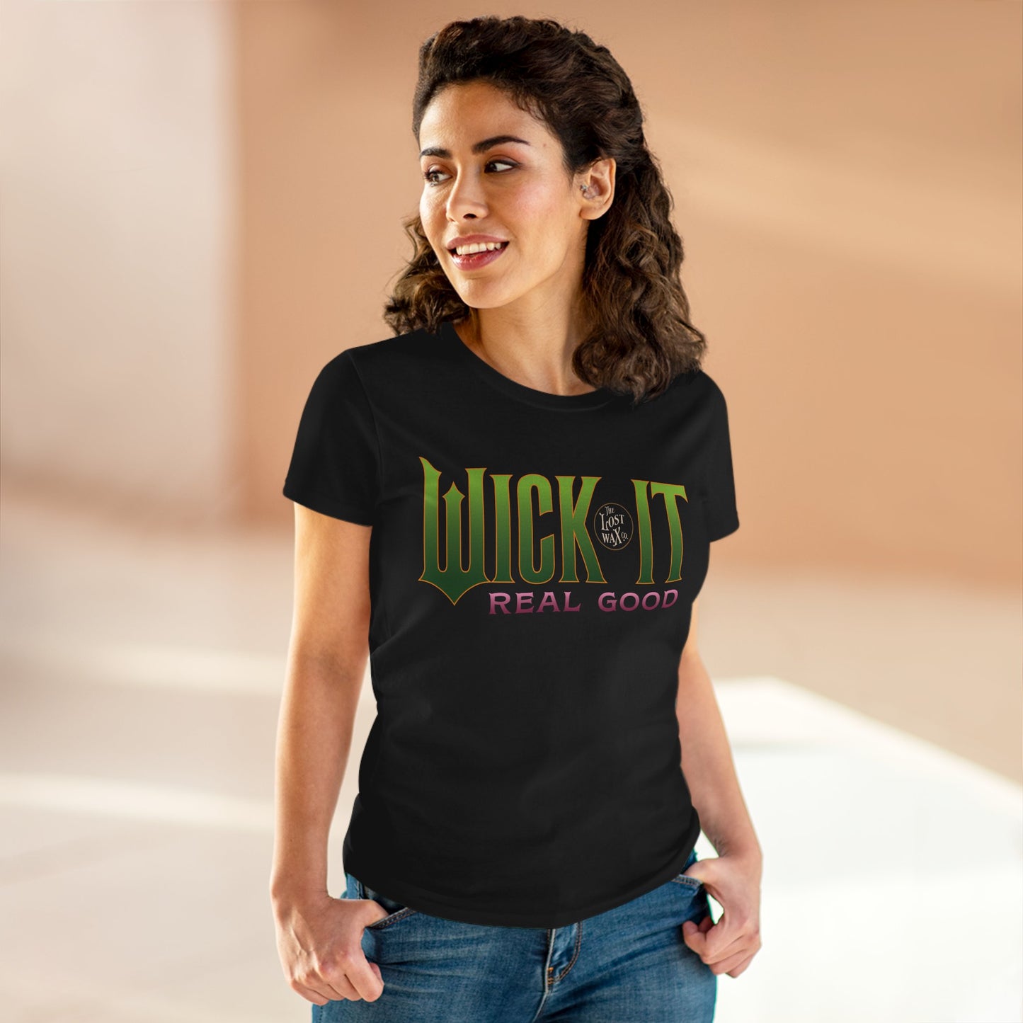 Woman wearing a black t-shirt with 'Wick It Real Good' text on a beige background