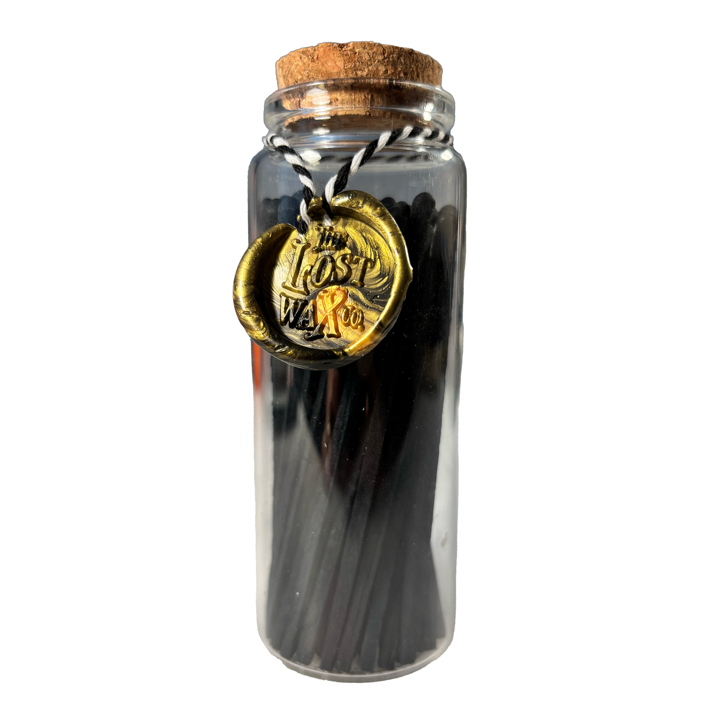 Glass jar with cork lid containing black safety matches and a gold seal labeled 'The Lost Weft Co.' on a white background.