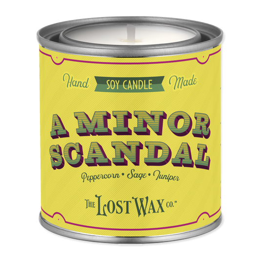 Candle canister labeled 'A Minor Scandal' by The Lost Wax Co. on a white background