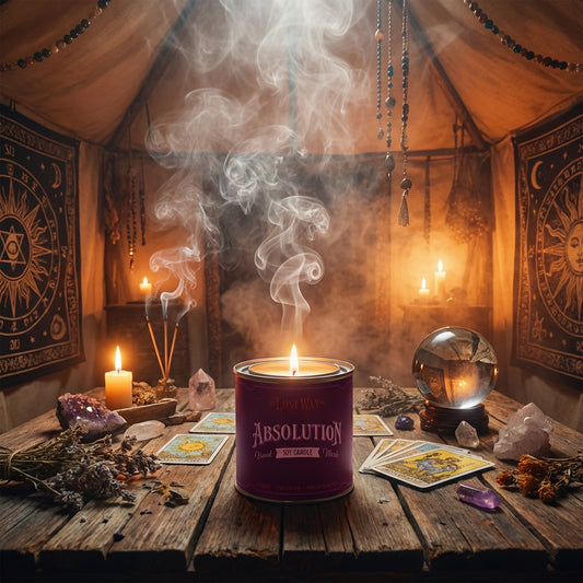 Purple candle labeled 'Absolution' on a wooden table with candles and cards in a mystical setting.