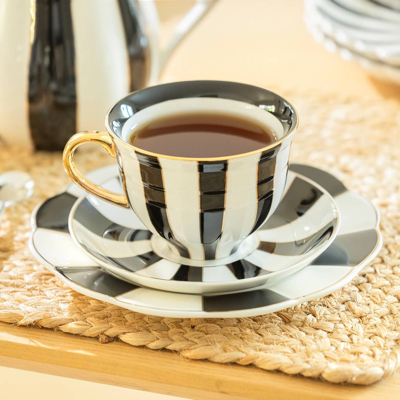 Black and white striped teacup with saucer on a woven mat