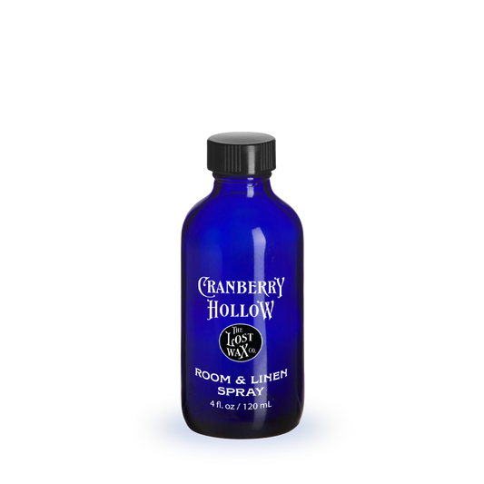 Blue bottle of 'Cranberry Hollow' room & liner spray on a white background