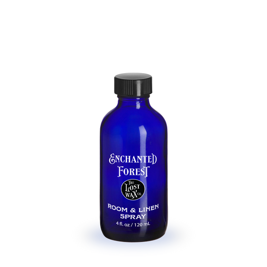 Blue bottle of 'Enchanted Forest' room & linen spray on a white background