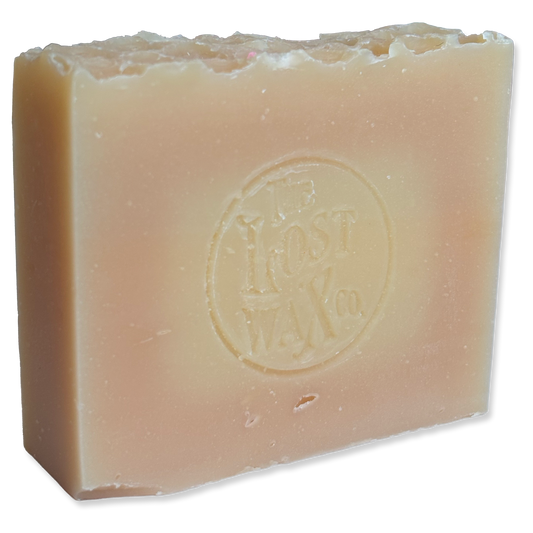 A bar of pale amber soap stamped with The Lost Wax Co. seal.