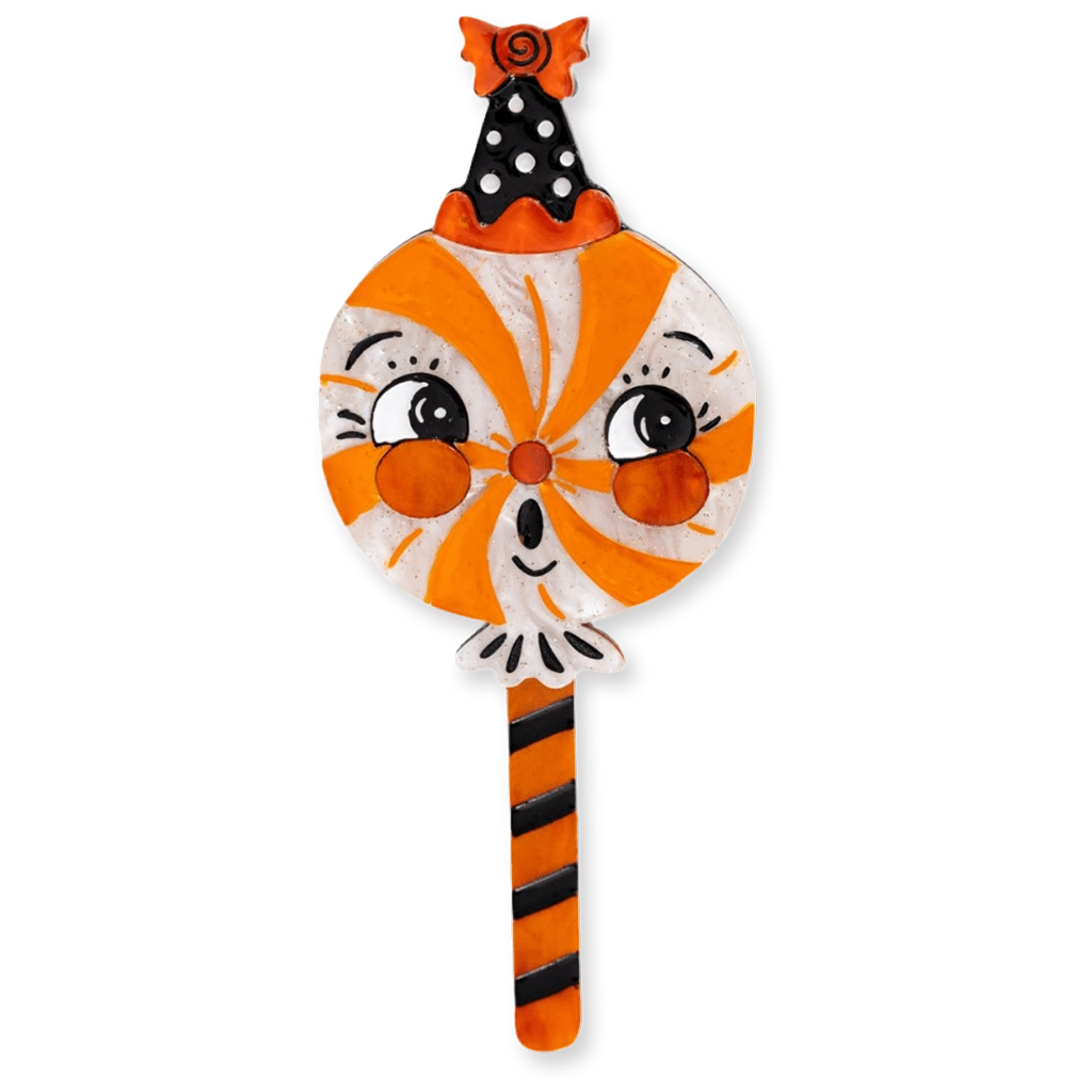 A decorative Halloween-themed brooch featuring a cartoon cat face with orange and white swirls, black polka-dot ears, and an orange-and-black striped stick, shown on a plain white background.