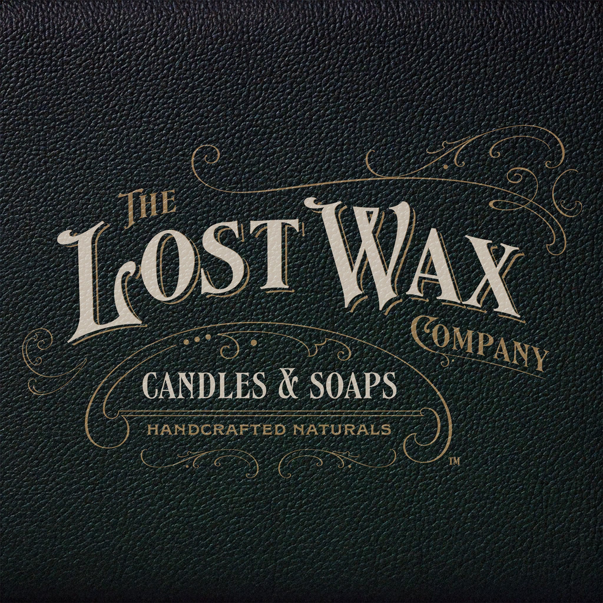 Logo of The Lost Wax Company on a dark leather textured background