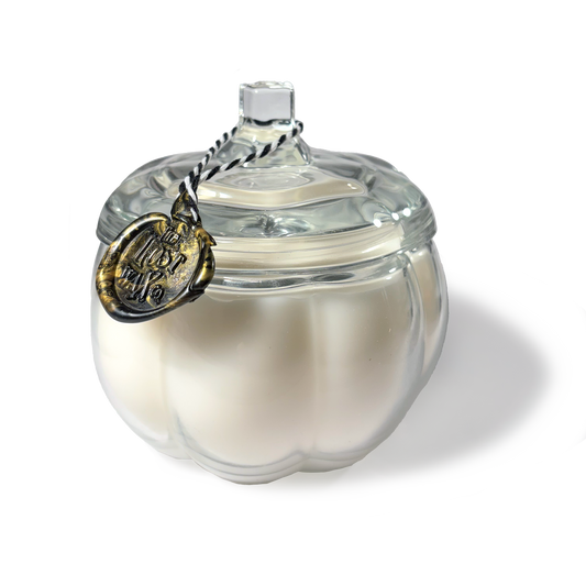 White ceramic pumpkin-shaped container with a clear glass lid on a white background