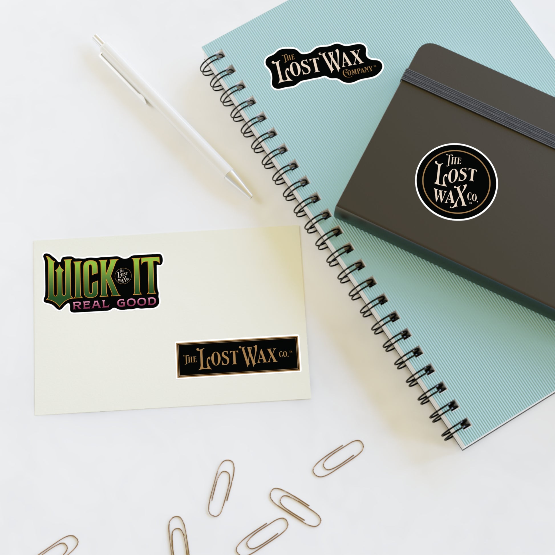 Notebooks and stationery items with 'The Lost Wax Co.' branding on a white background