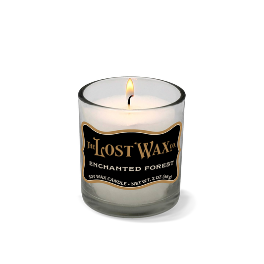 Candle in a glass container with 'The Lost Wax Company' branding on a white background