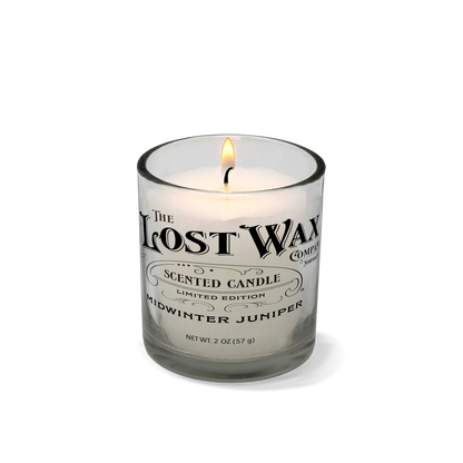 Midwinter Juniper Candle in a glass container with 'The Lost Wax Company' branding on a white background