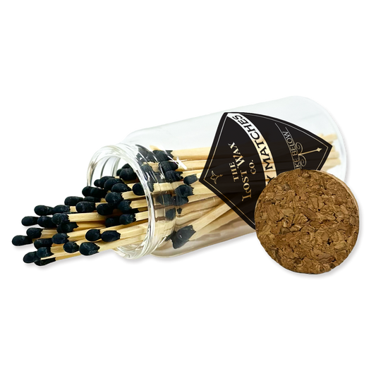 Matches with a clear glass container and cork lid on a white background