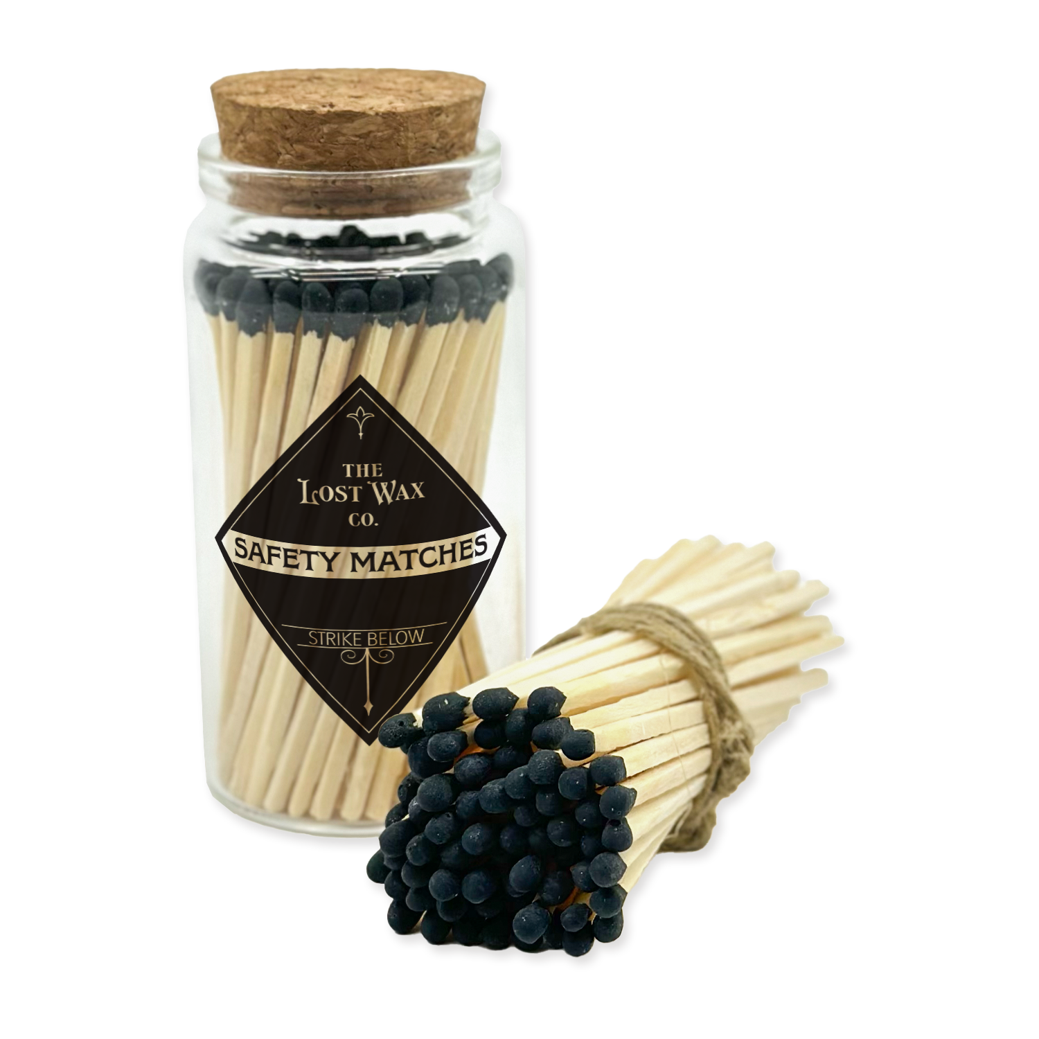 Jar of safety matches with a cork lid and a bundle of matches on a white background, featuring 'The Lost Wax Co.' branding.