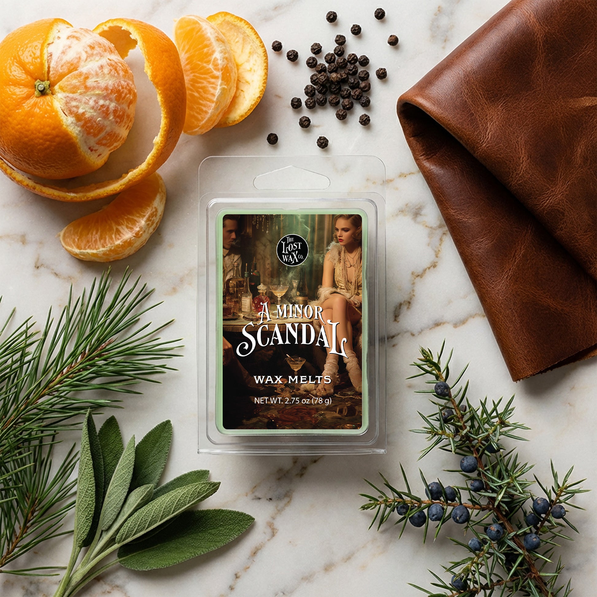 Wax melt package labeled 'A Minor Scandal' surrounded by decorative elements on a marble surface.