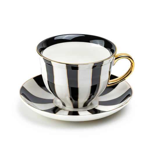 Black and white striped teacup and saucer with gold trim on a white background