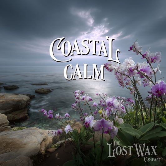 Orchids by a rocky coastline with a dramatic sky, featuring 'The Lost Wax Company' logo.