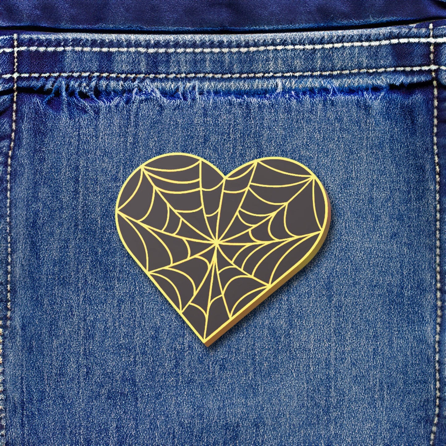 Heart-shaped spider web design on a denim background