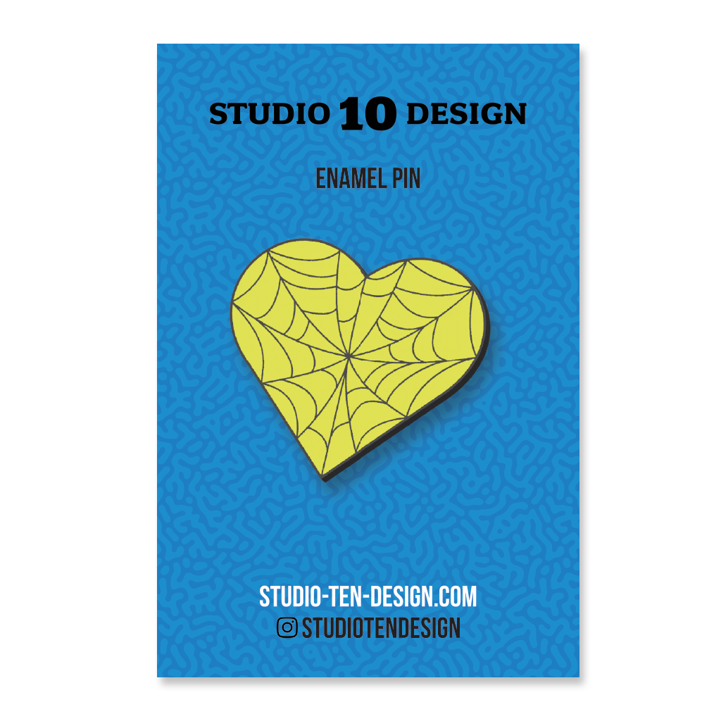 Yellow heart-shaped spider web design on a blue card with 'Studio 10 Design' text.