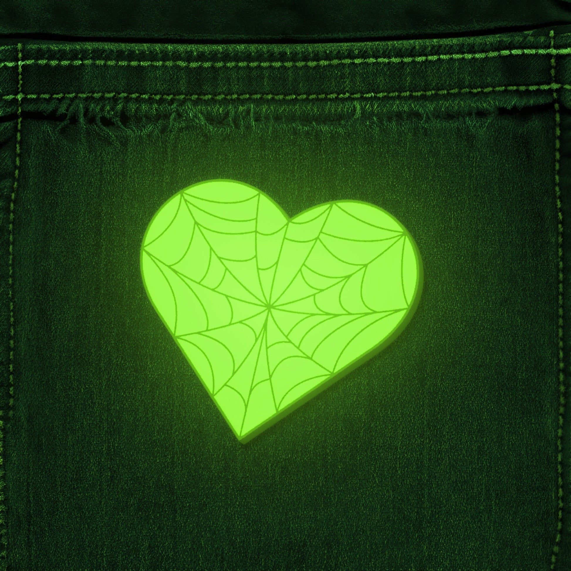 Glowing heart-shaped spider web design on a denim fabric background