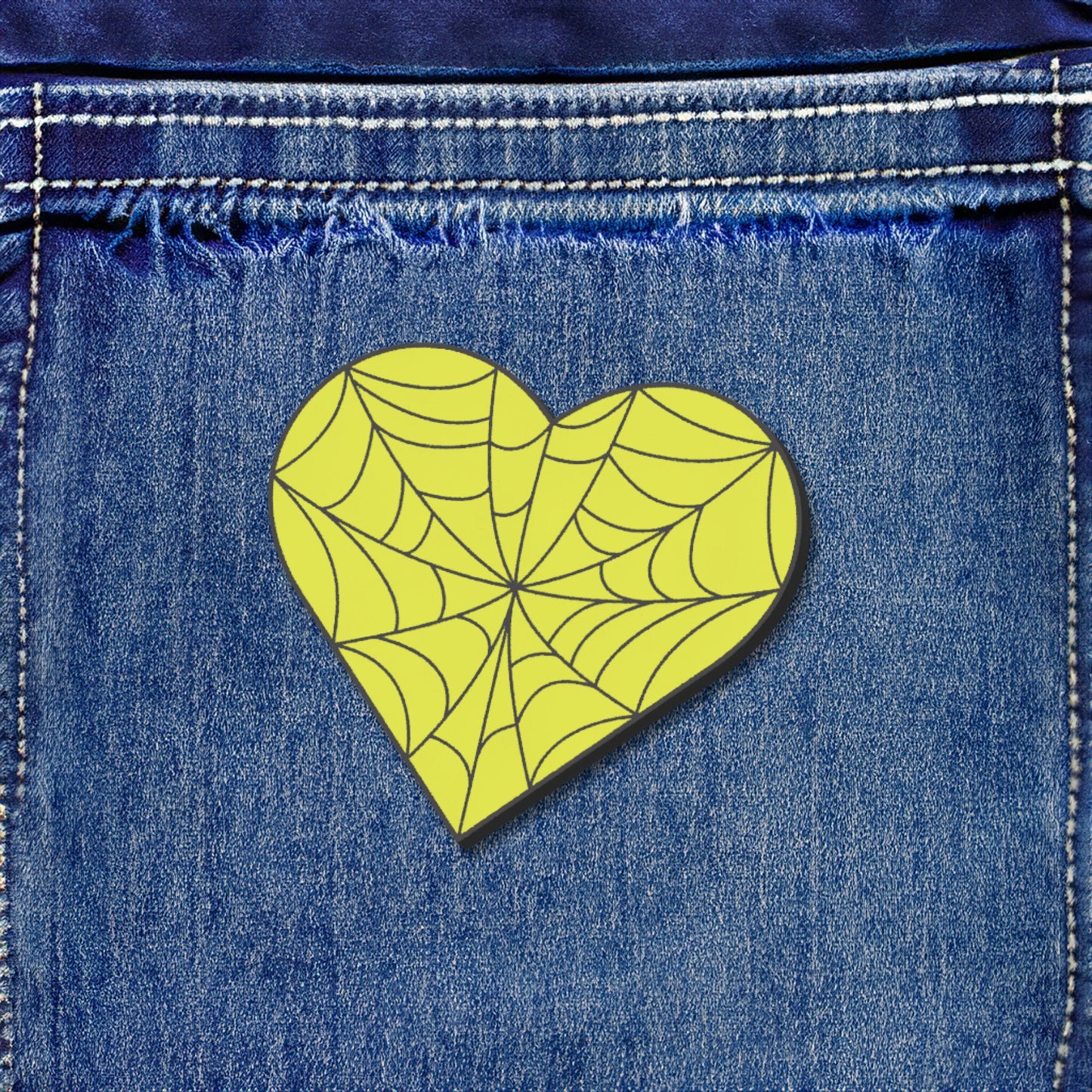 Heart-shaped spider web design on blue denim fabric