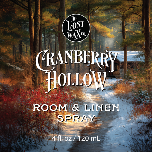 Label for 'Cranberry Hollow' room & linen spray by The Lost Wax Co. with a forest scene in the background.