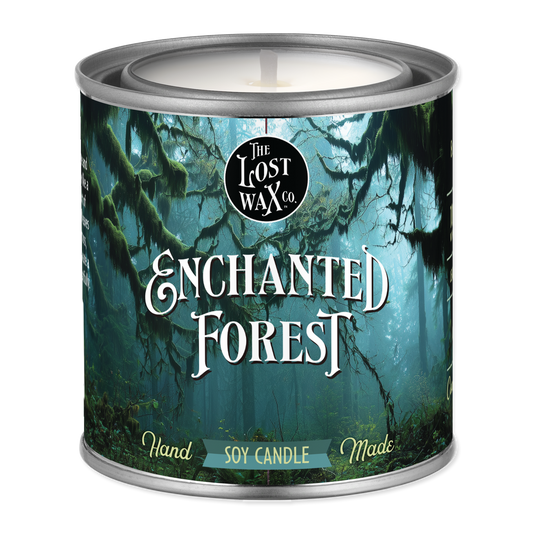 Candle in a can labeled 'Enchanted Forest' by The Lost Wax Co.