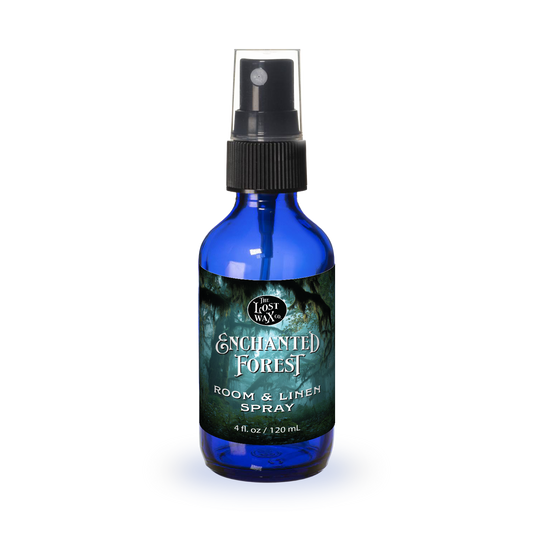 Blue spray bottle labeled 'Enchanted Forest' on a white background