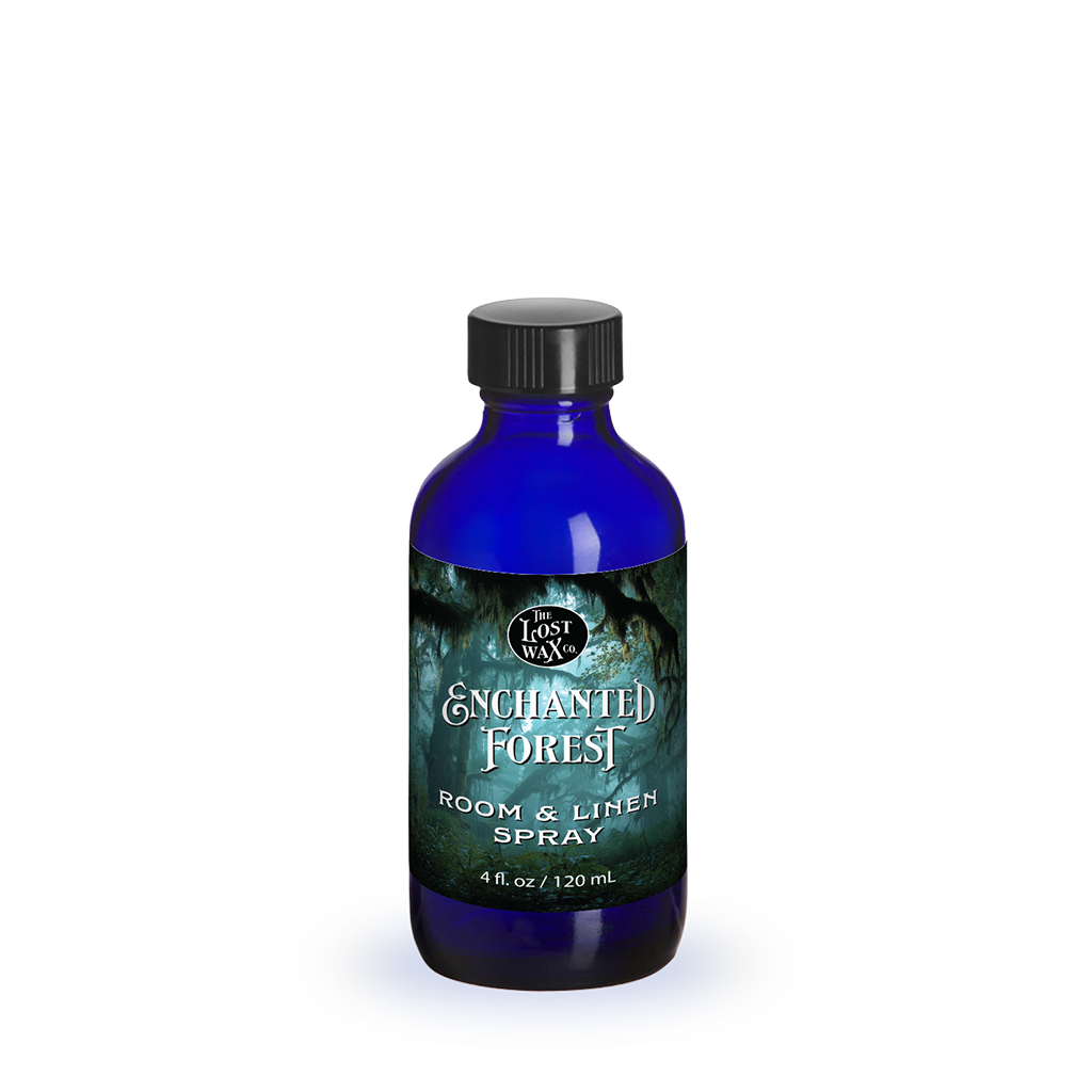 Blue bottle of 'Enchanted Forest' room & linen spray on a white background
