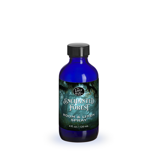 Blue bottle of 'Enchanted Forest' room & linen spray on a white background