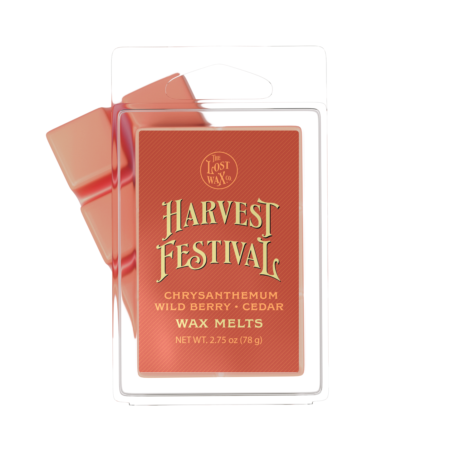 A package of Harvest Festival wax melts by The Lost Wax Co. The product is shown in its clear plastic clamshell packaging with a terracotta red label featuring gold lettering, with two reddish-orange wax melts visible behind it.