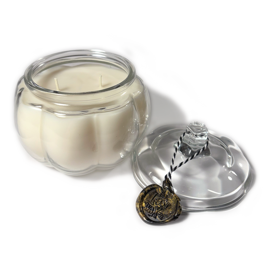 Candle in a glass jar with a decorative lid on a white background