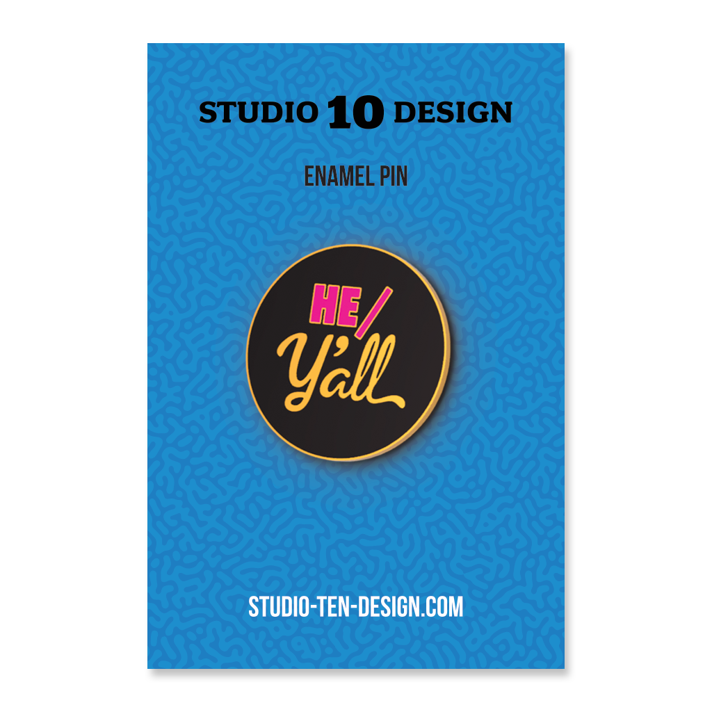 Enamel pin with 'HE/Y'ALL' design on a blue card with Studio 10 Design branding.