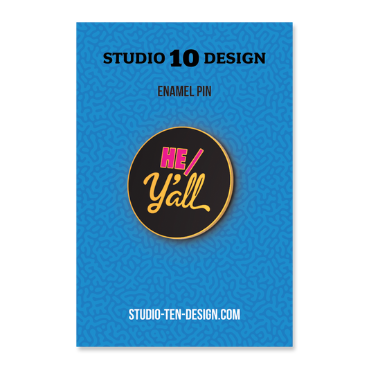 Enamel pin with 'HE/Y'ALL' design on a blue card with Studio 10 Design branding.