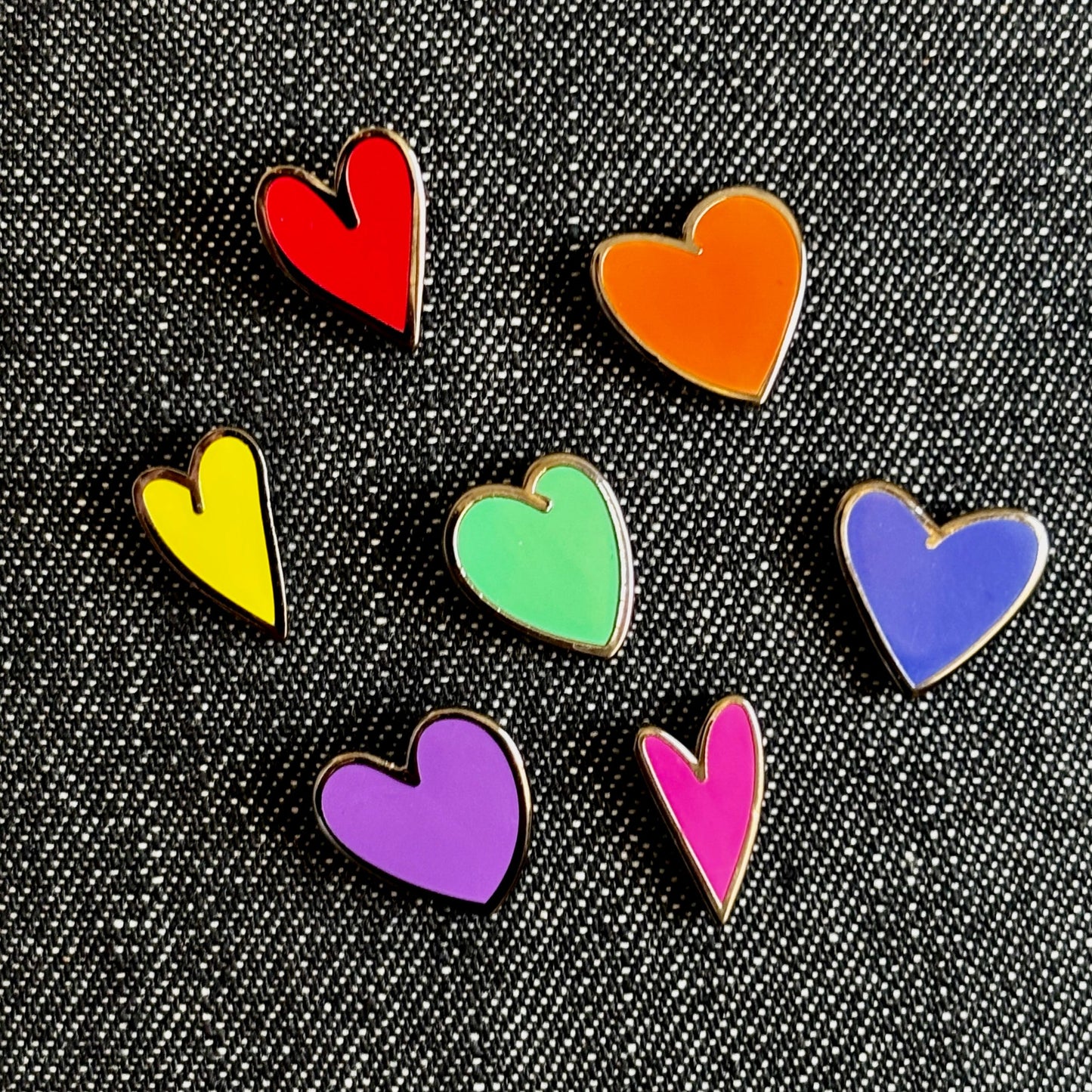 Set of 7 Mini Rainbow Heart Enamel Pins (shown on dark denim fabric) by Studio Ten Design
