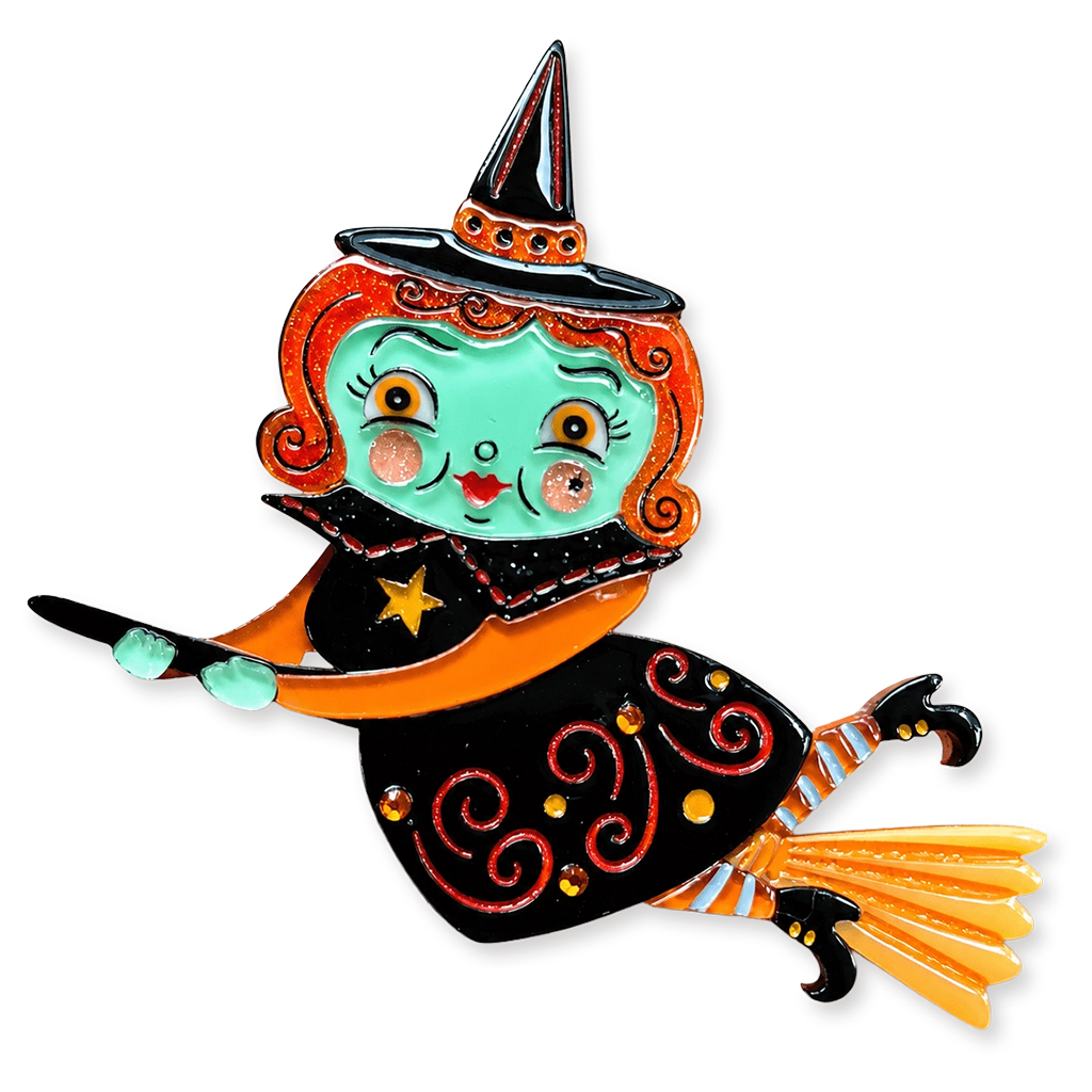 A whimsical witch pin featuring a turquoise face, orange hair, a black hat with orange trim, and a black dress with red swirls, orange accents, and a yellow broom, isolated on a white background.