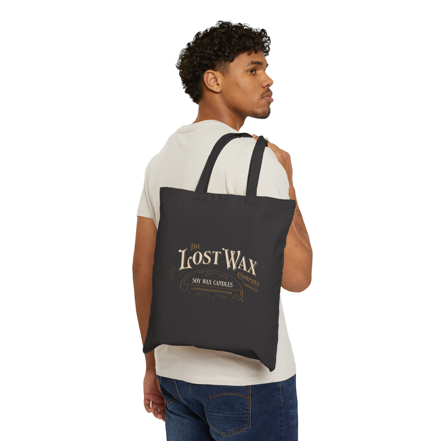 Man carrying a black tote bag with 'Lost Wax' branding on a white background