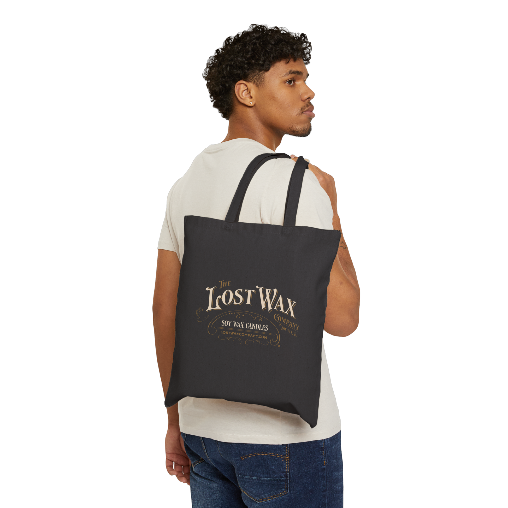 Man carrying a black tote bag with 'Lost Wax' branding on a white background