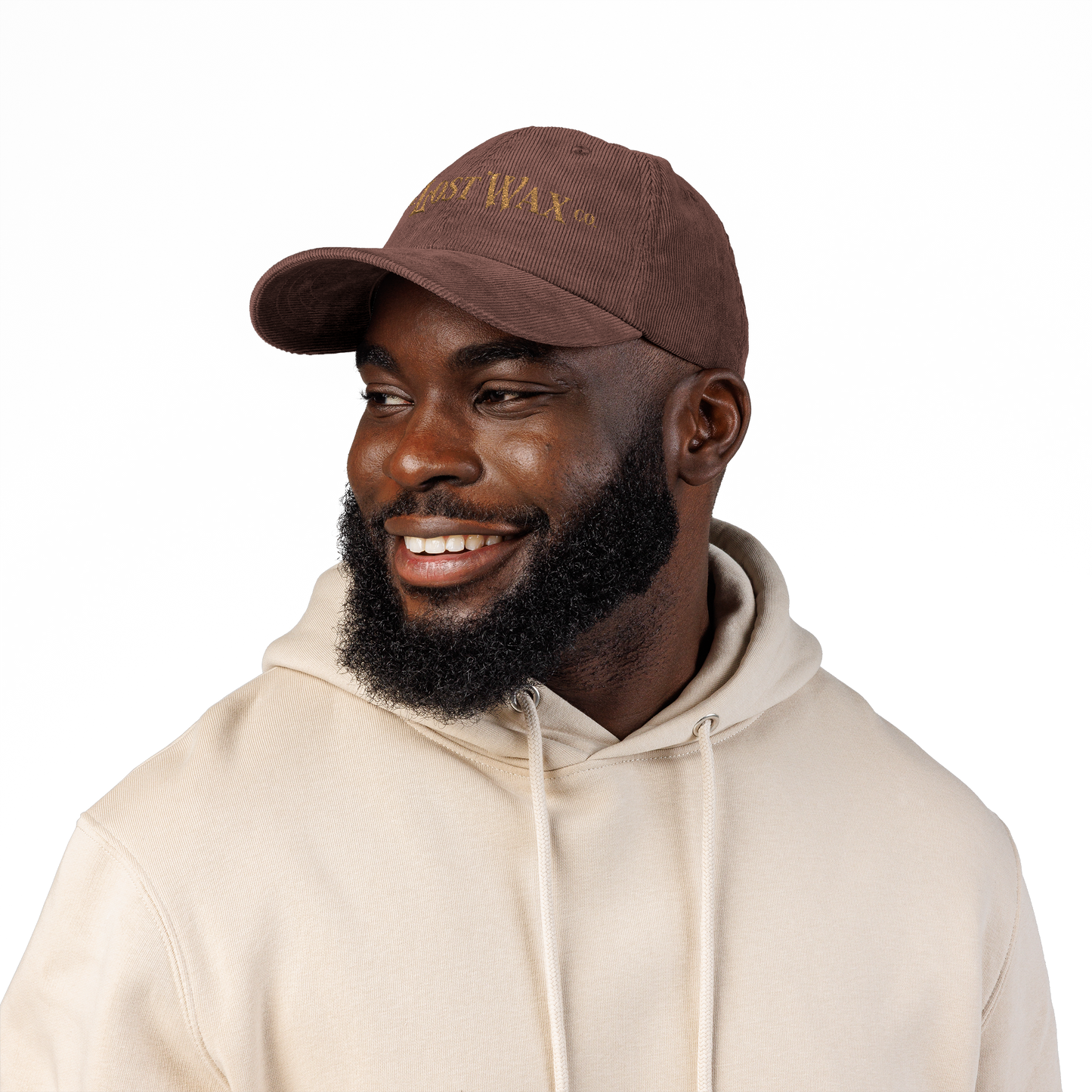 Man wearing a brown cap and beige hoodie on a white background