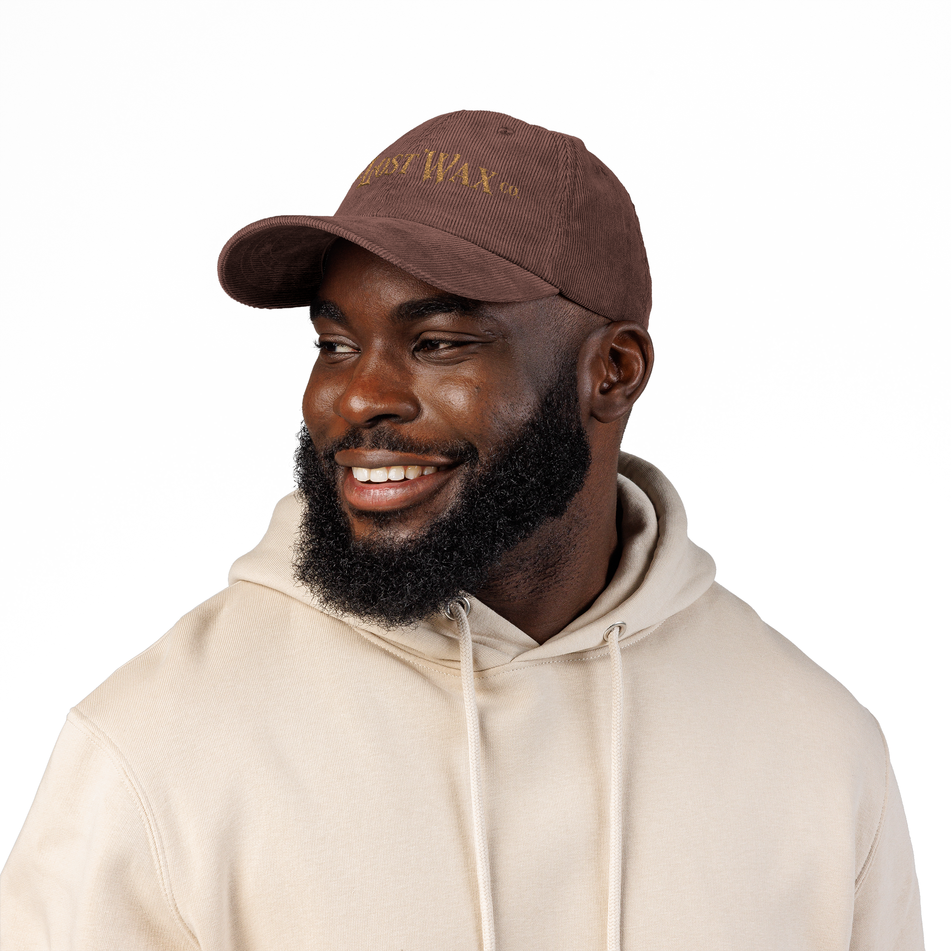 Man wearing a brown cap and beige hoodie on a white background