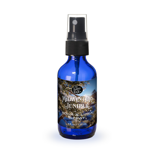 Blue spray bottle labeled 'Midwinter Juniper' on a white background