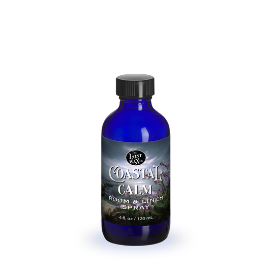 Blue bottle of 'Coastal Calm' room & linen spray on a white background