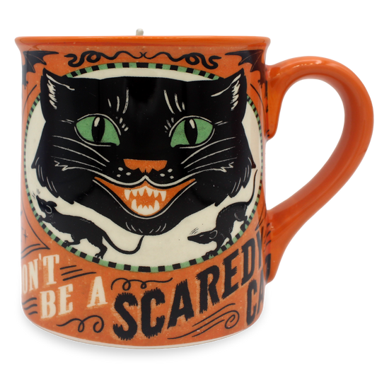 An orange ceramic mug featuring a vintage-style illustration of a black cat with green eyes and the text 'DON'T BE A SCARED CAT'.