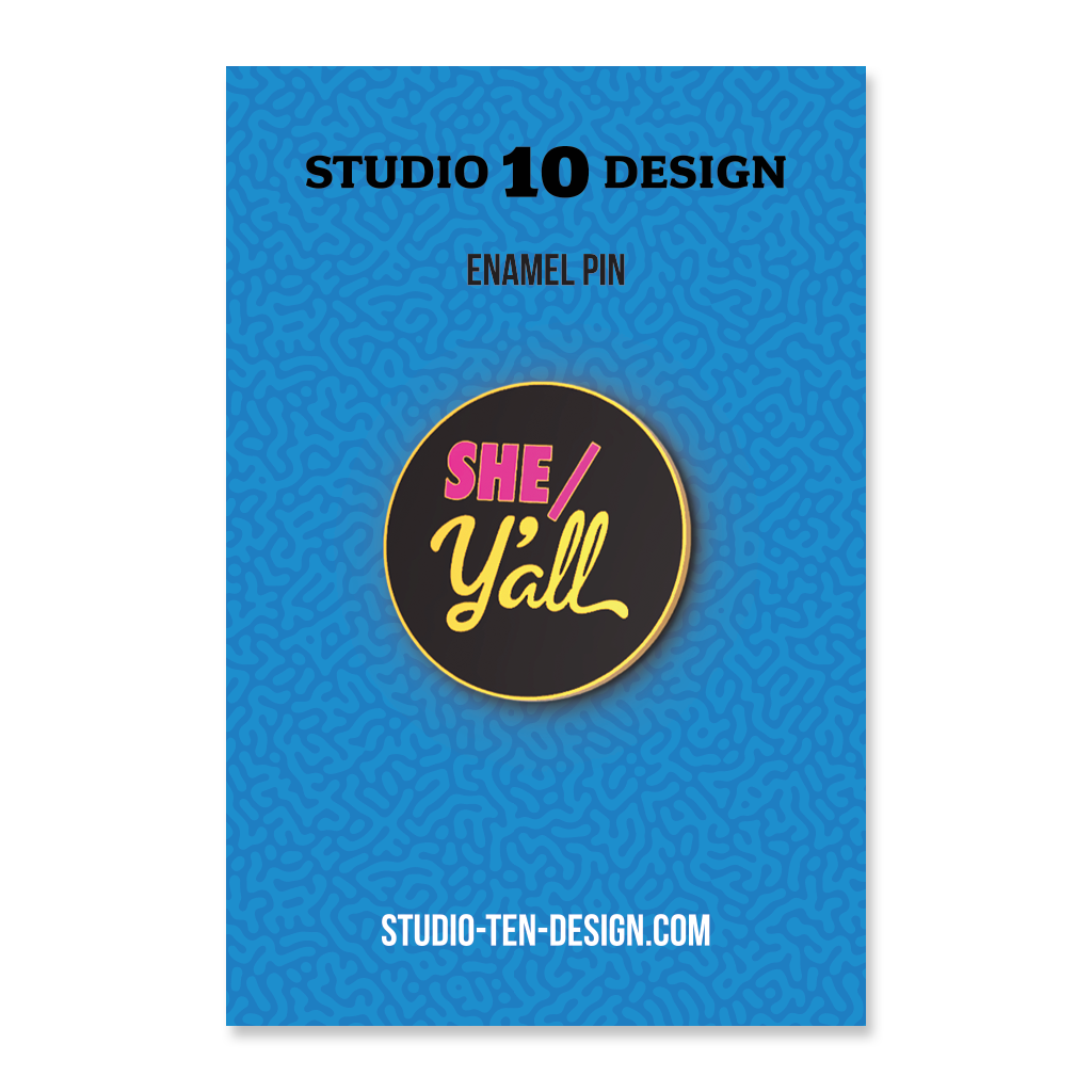 Enamel pin packaging with 'SHE/Y'all' design on a blue background