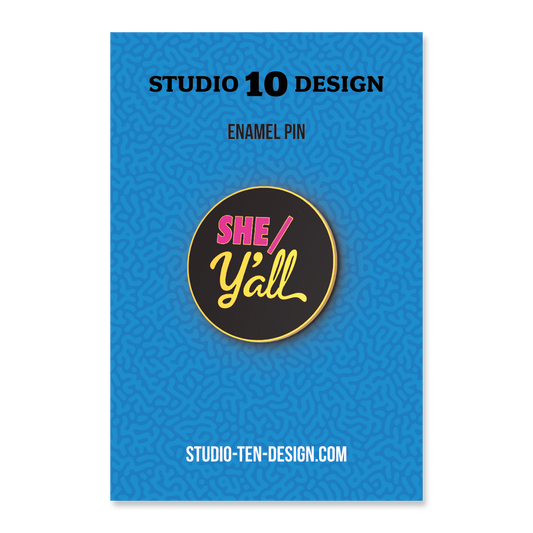 Enamel pin packaging with 'SHE/Y'all' design on a blue background