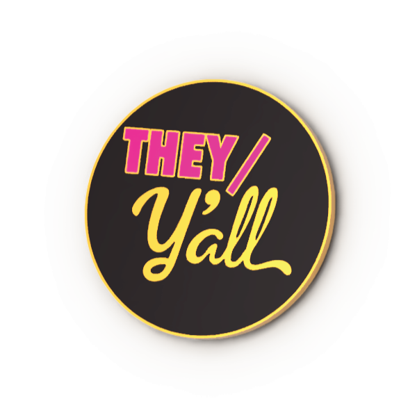 Round black enamel pin with 'THEY/Y'all' text in pink and yellow on a white background