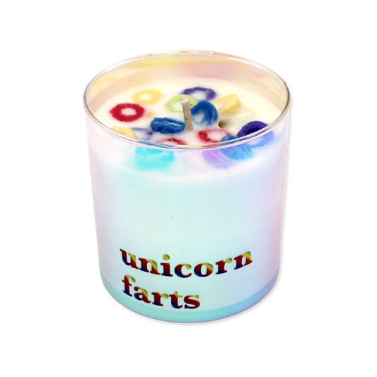 Rainbow iridescent candle with 'unicorn farts' text on a white background
