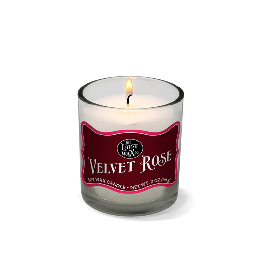 Candle in a glass jar with a red label on a white background