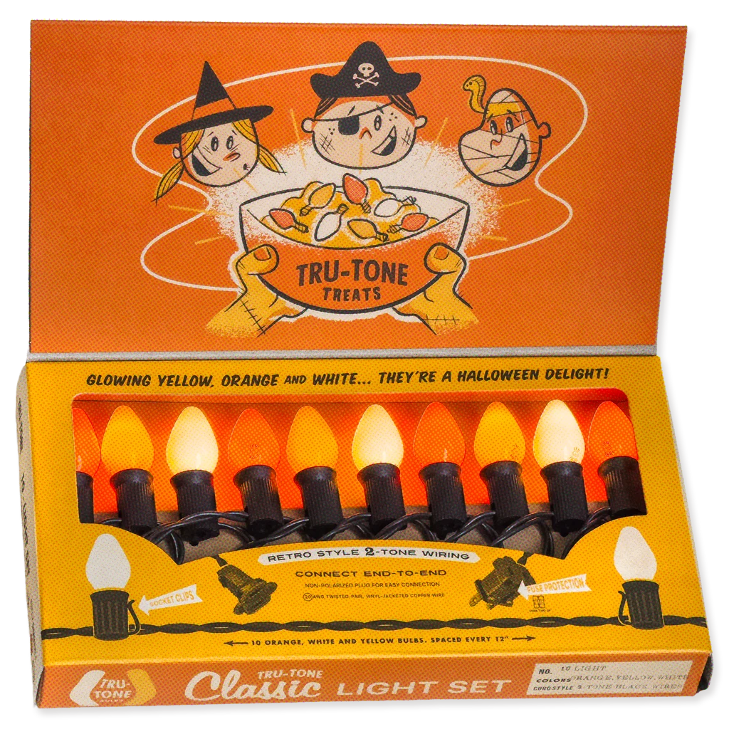 A boxed Halloween-style light set labeled Tru-Tone Classic Light Set, with an orange illustrated lid and a tray of six C7 lights in yellow, orange, and white. The packaging prominently shows Tru-Tone branding and Halloween-themed cartoon graphics.