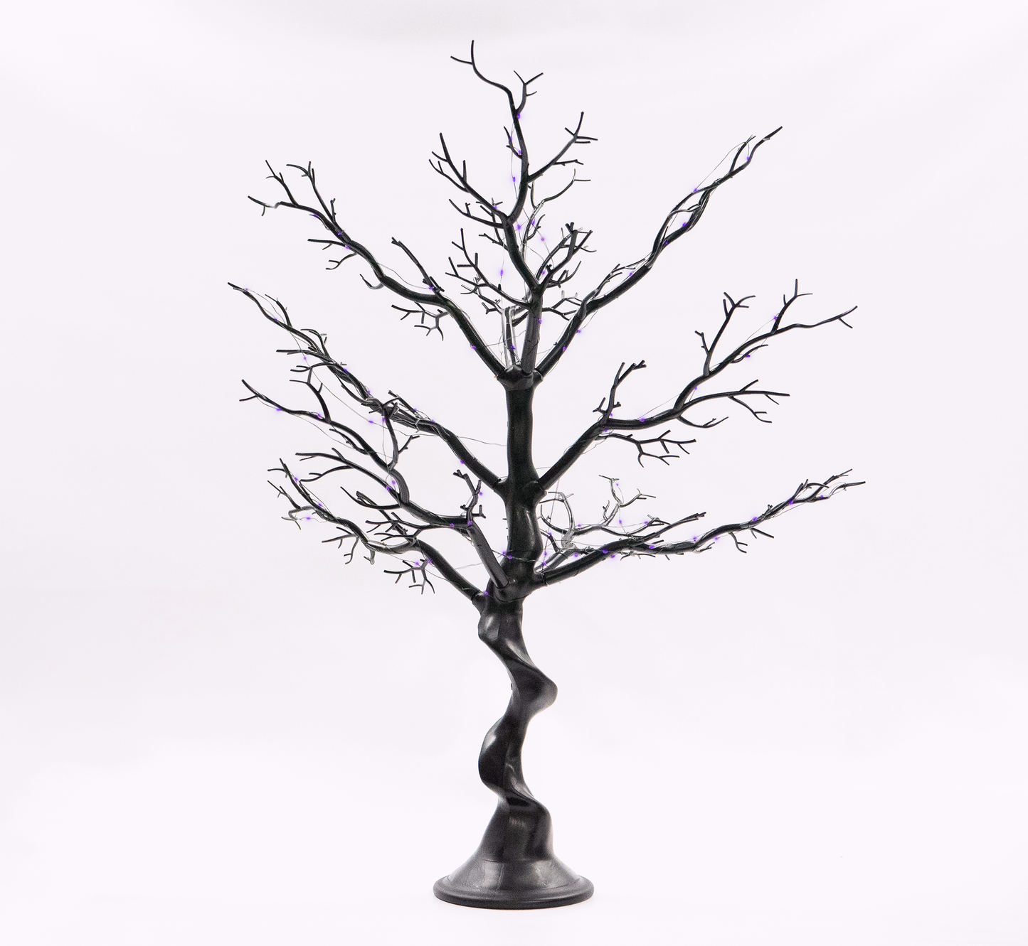 Black artificial tree with twisted trunk on a white background