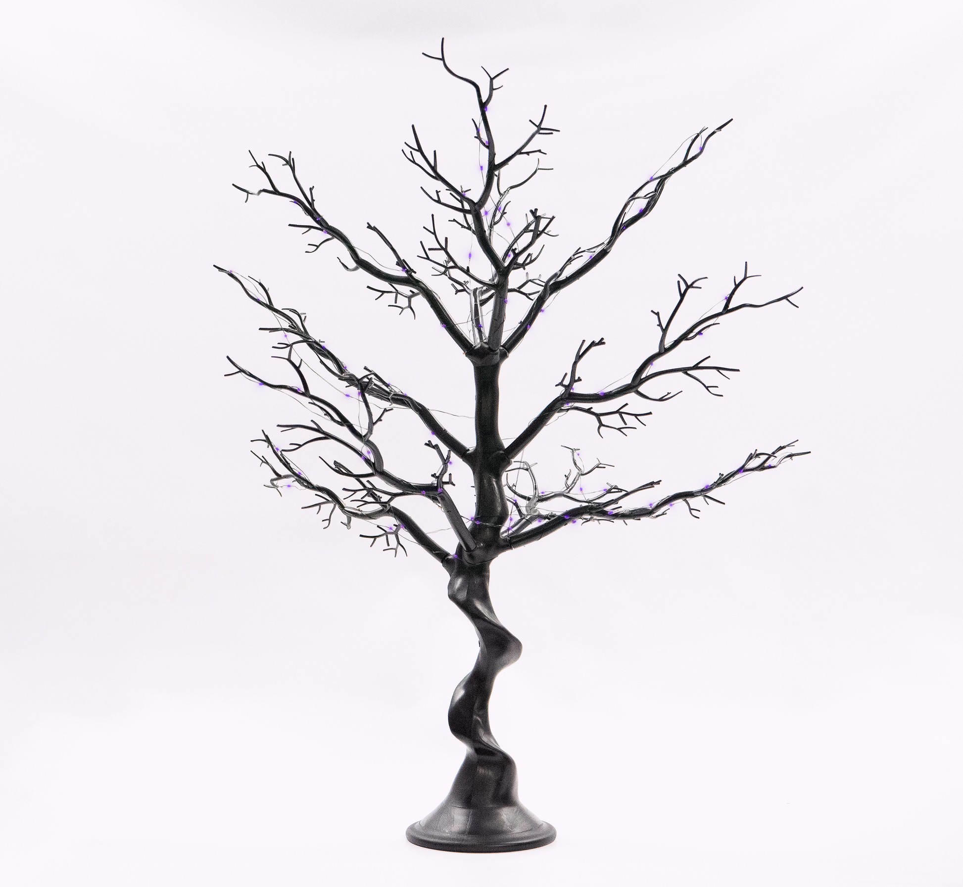 Black artificial tree with twisted trunk on a white background