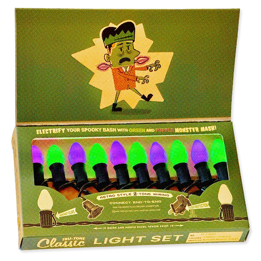 A boxed Halloween-style light set with cartoon Frankenstein graphics on the packaging. The open box shows multiple bulb-shaped lights in green and purple colors, with text reading 'Electrify Your Spooky Bash with Green and Purple Monster Mash!' and 'Tri-Tone Classic Light Set.